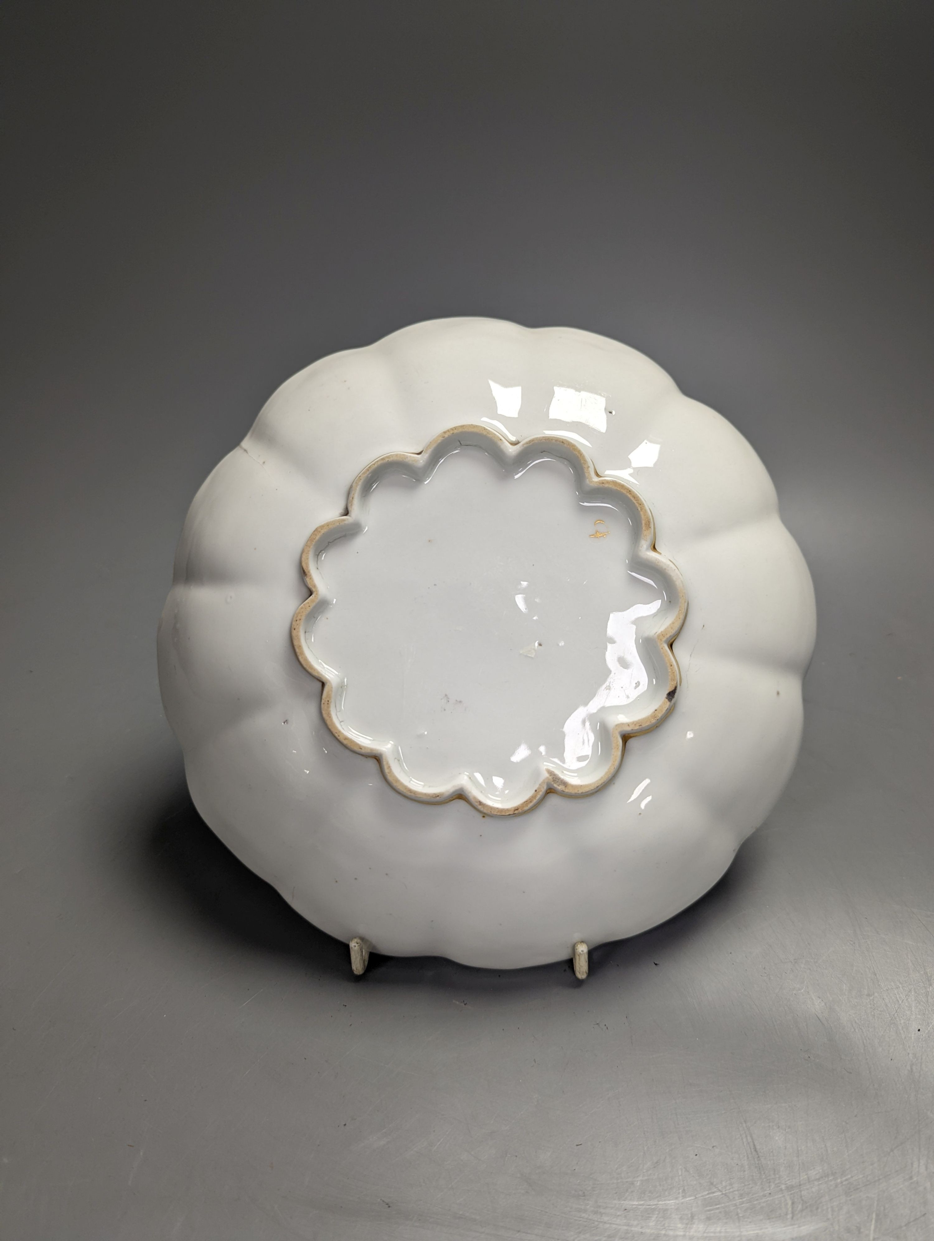 A Chelsea-Derby circular dish painted in puce with a cherub floating on a cloud by Richard Askew, c.1775, 22cm